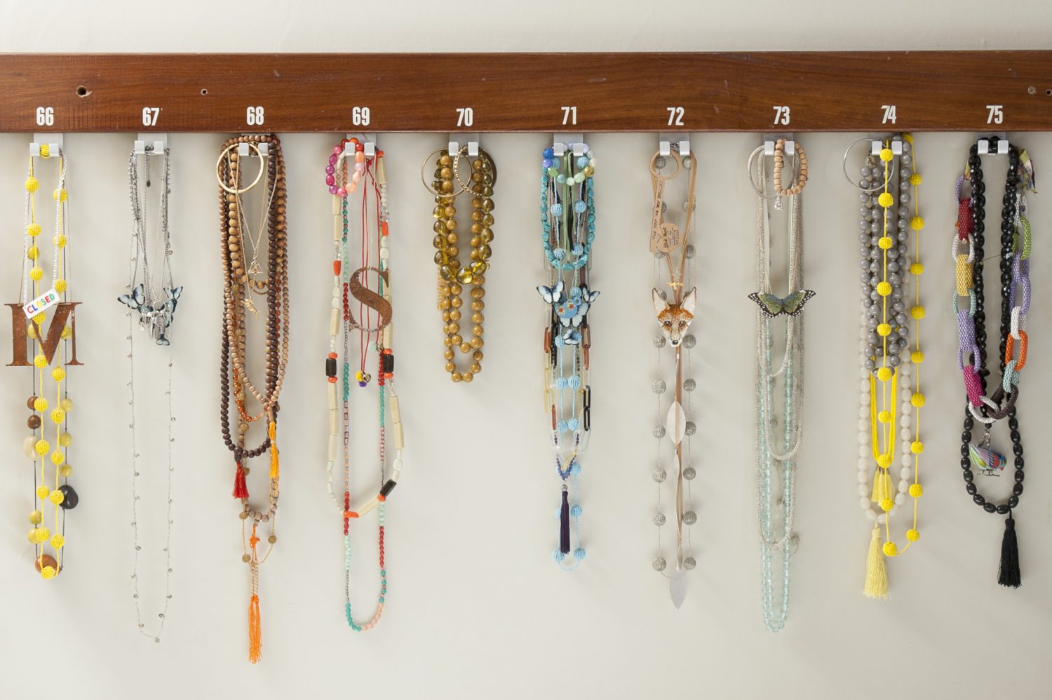 Sarah’s collection of necklaces hangs from a row of salvaged school coat hooks