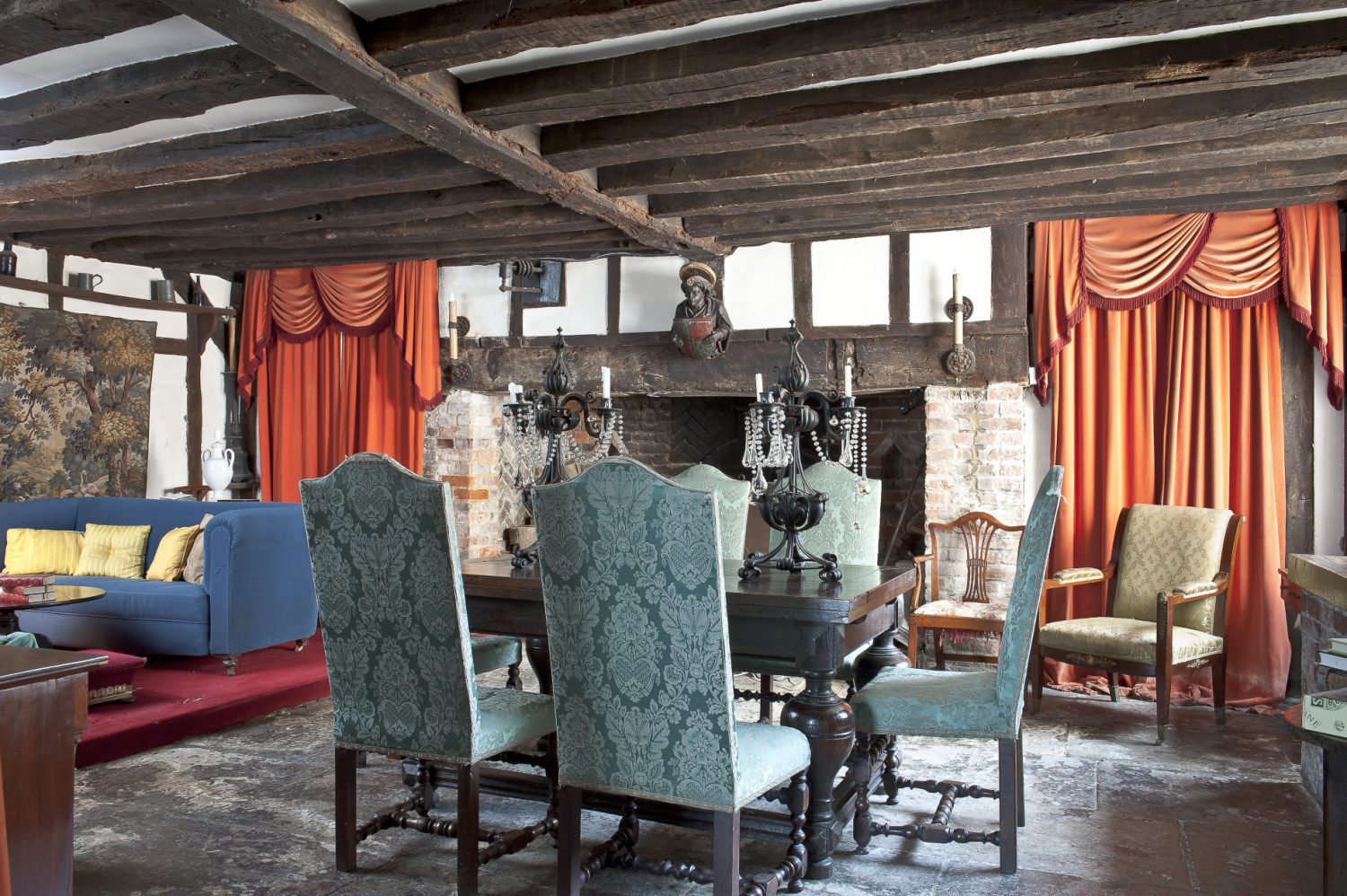 Doors from the hallway lead into a low-beamed dining room with an enormous inglenook fireplace