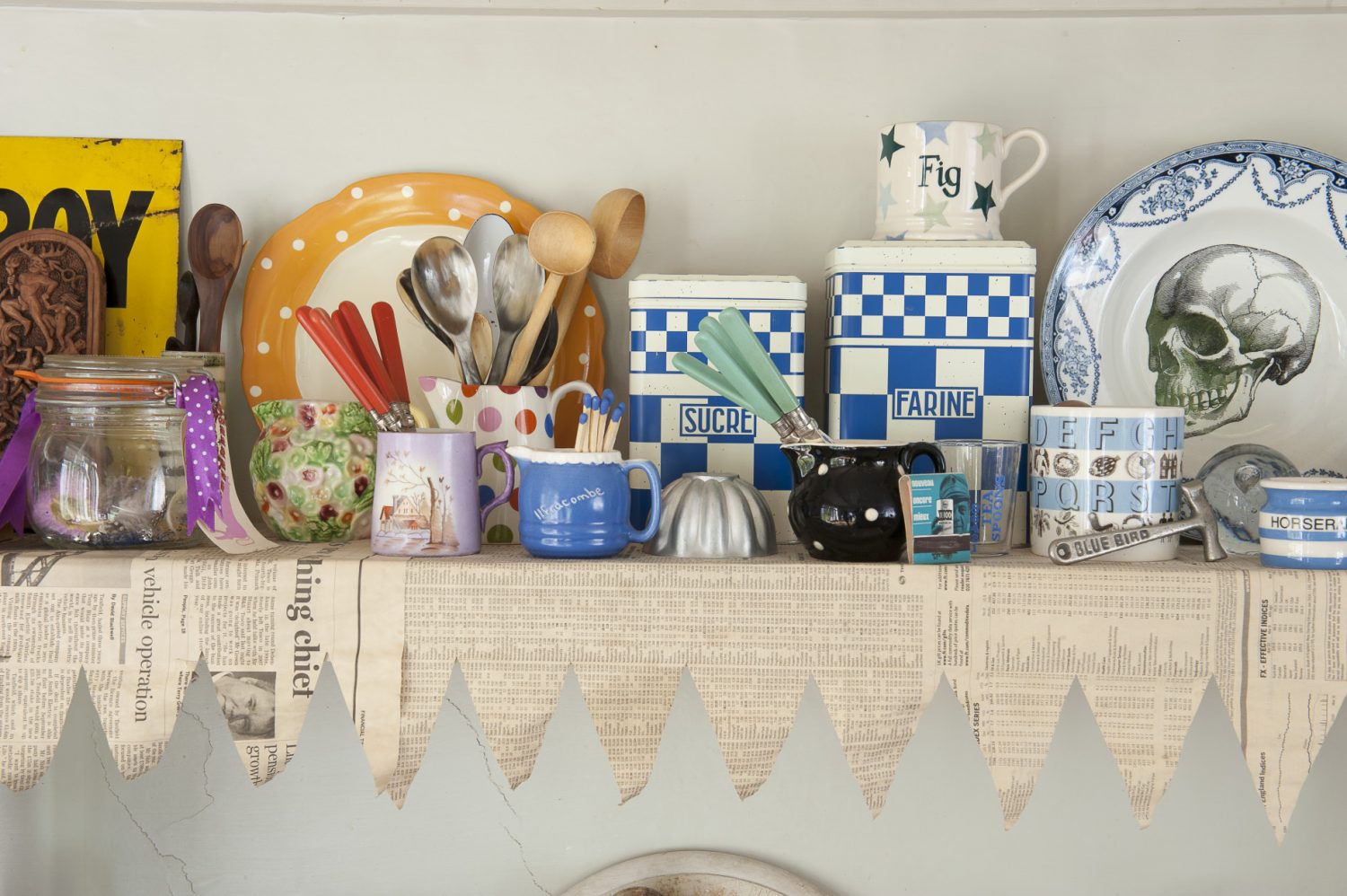 Above the old-fashioned, porcelain sink, shelves that support a collection of Cornish creamware have been lined with newspaper with a precisely cut zigzag edge, so that it looks like bunting