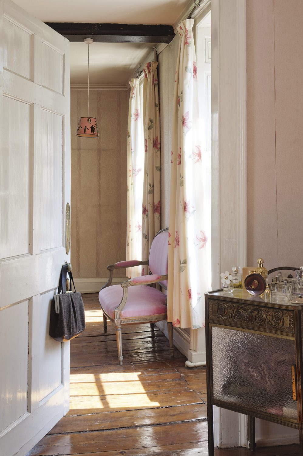 A door from Gabby and Russell’s bedroom leads to a dressing room with a glass and metal table where Gabby keeps her perfume bottles and small accessories