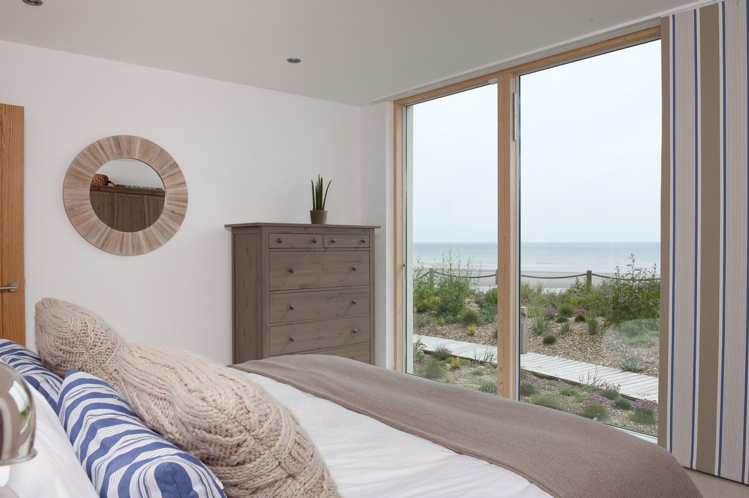 In the other wing another guest bedroom, facing the sea, is decorated in softer shades of taupe, ecru and slate blue