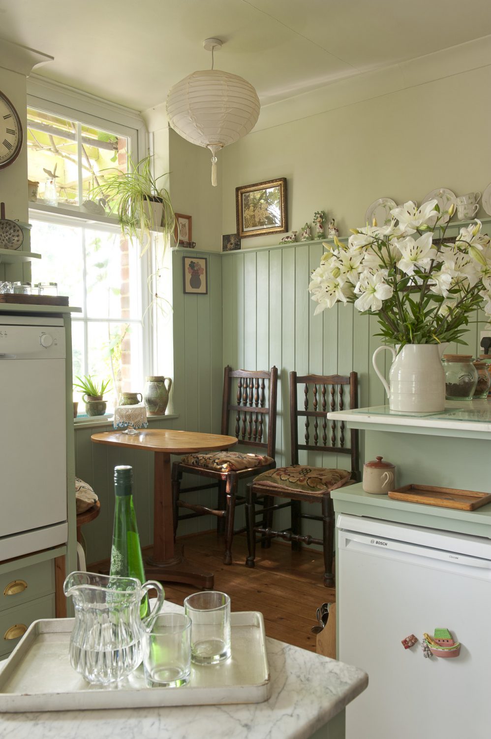 A little alcove breakfast table for two is nestled in one corner of the modest-sized shaker-style kitchen
