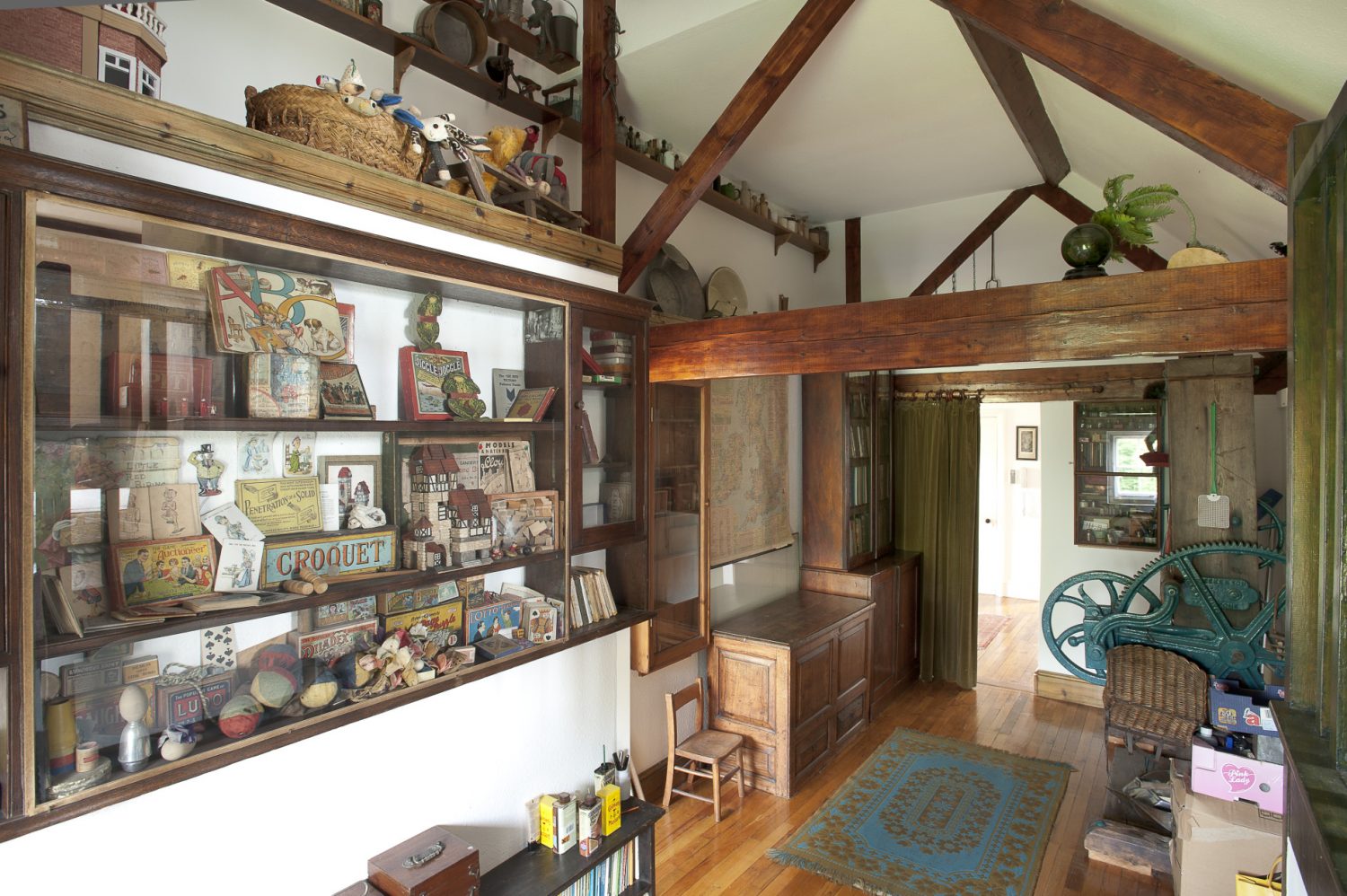 Upstairs a secondary hallway, home to an old hop press, has walls festooned with old farm tools, cabinets filled with children’s games and writing and drawing tools
