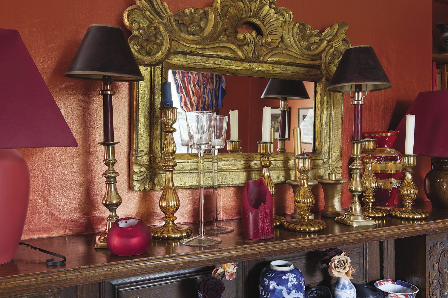 A collection of amber glass candlesticks lines the mantelpiece in the dining room