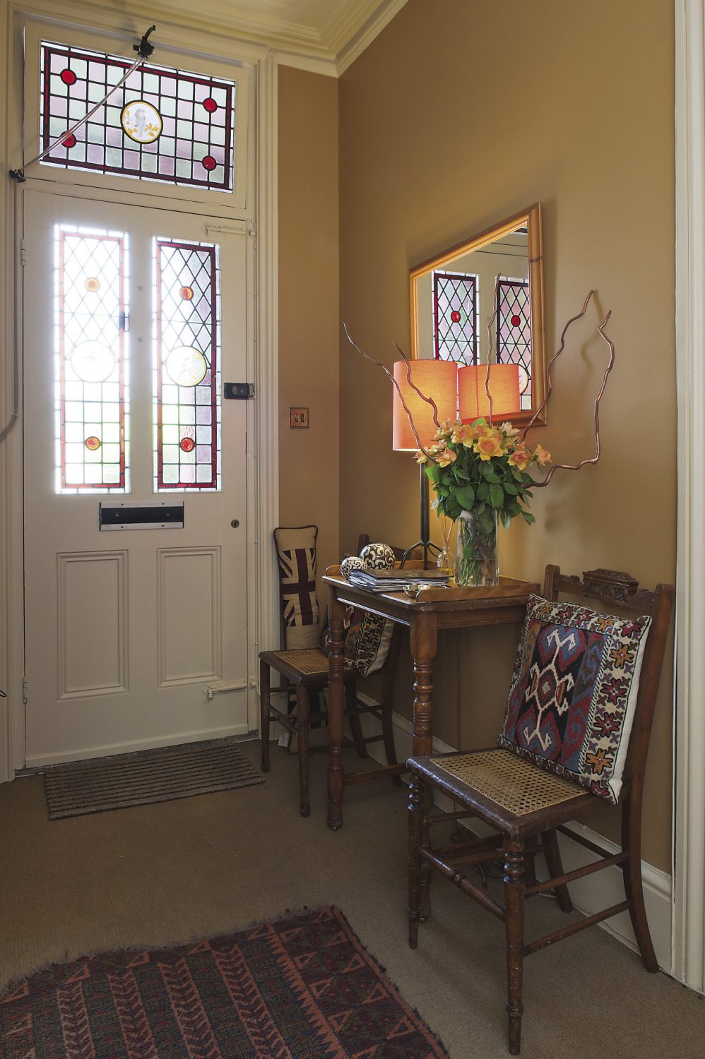 The inviting glow of the colours used in the hallway combined with the stained glass panels, provides a warm welcome to Ann Edwards’ Victorian villa