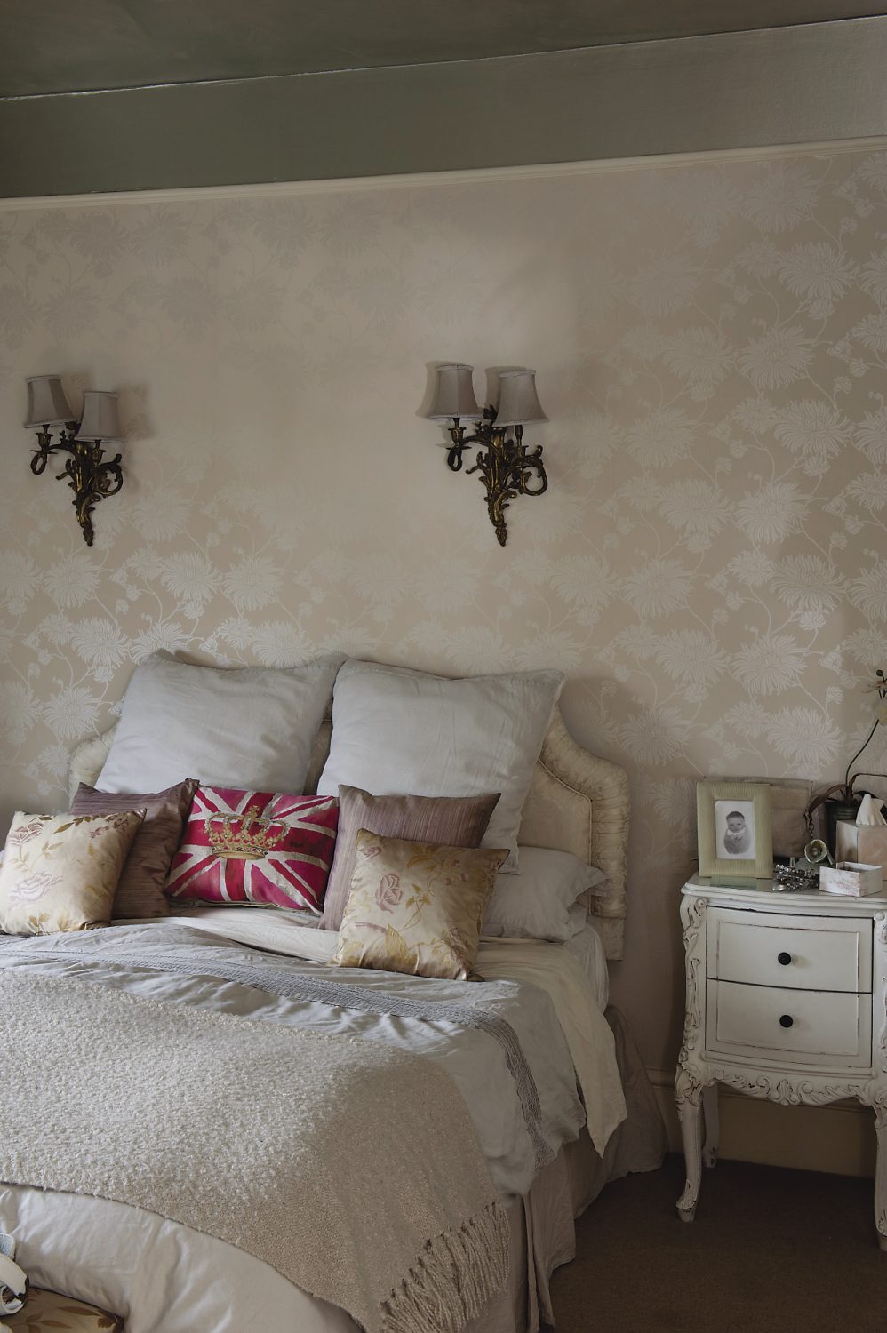 The chrysanthemum wallpaper has a subtle pearlised sheen that is echoed by the silver wash used on the ceiling. The bedlinen is a mix of fine linen and silk but in the centre of the bed is a Union Jack cushion with a crown in the centre