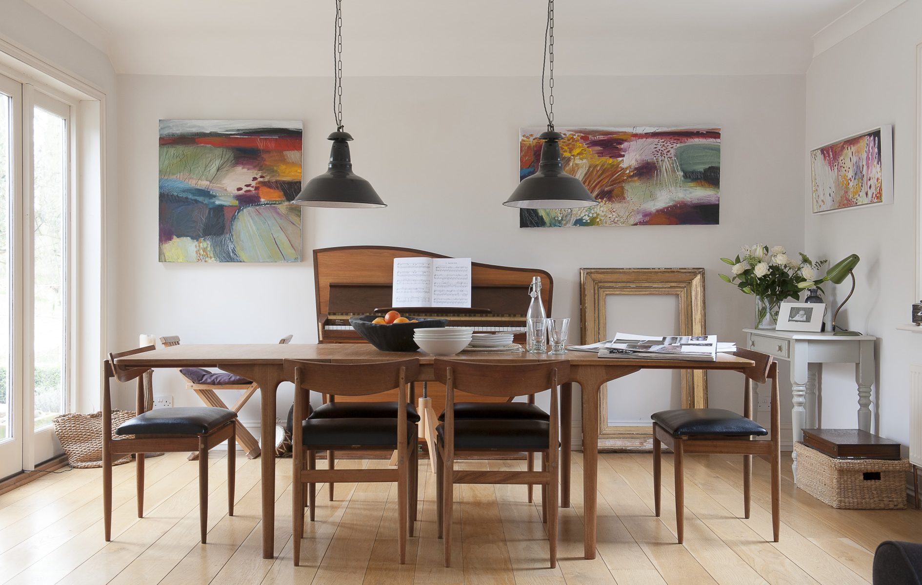 In the dining room, pride of place goes to the 1960s in the shape of a slim and elegant dining table over which hang a pair of old industrial lights from an antique shop in Hastings. Behind it is a wonderful ’60s Dutch Rippen upright piano