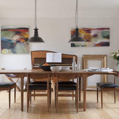 In the dining room, pride of place goes to the 1960s in the shape of a slim and elegant dining table over which hang a pair of old industrial lights from an antique shop in Hastings. Behind it is a wonderful ’60s Dutch Rippen upright piano