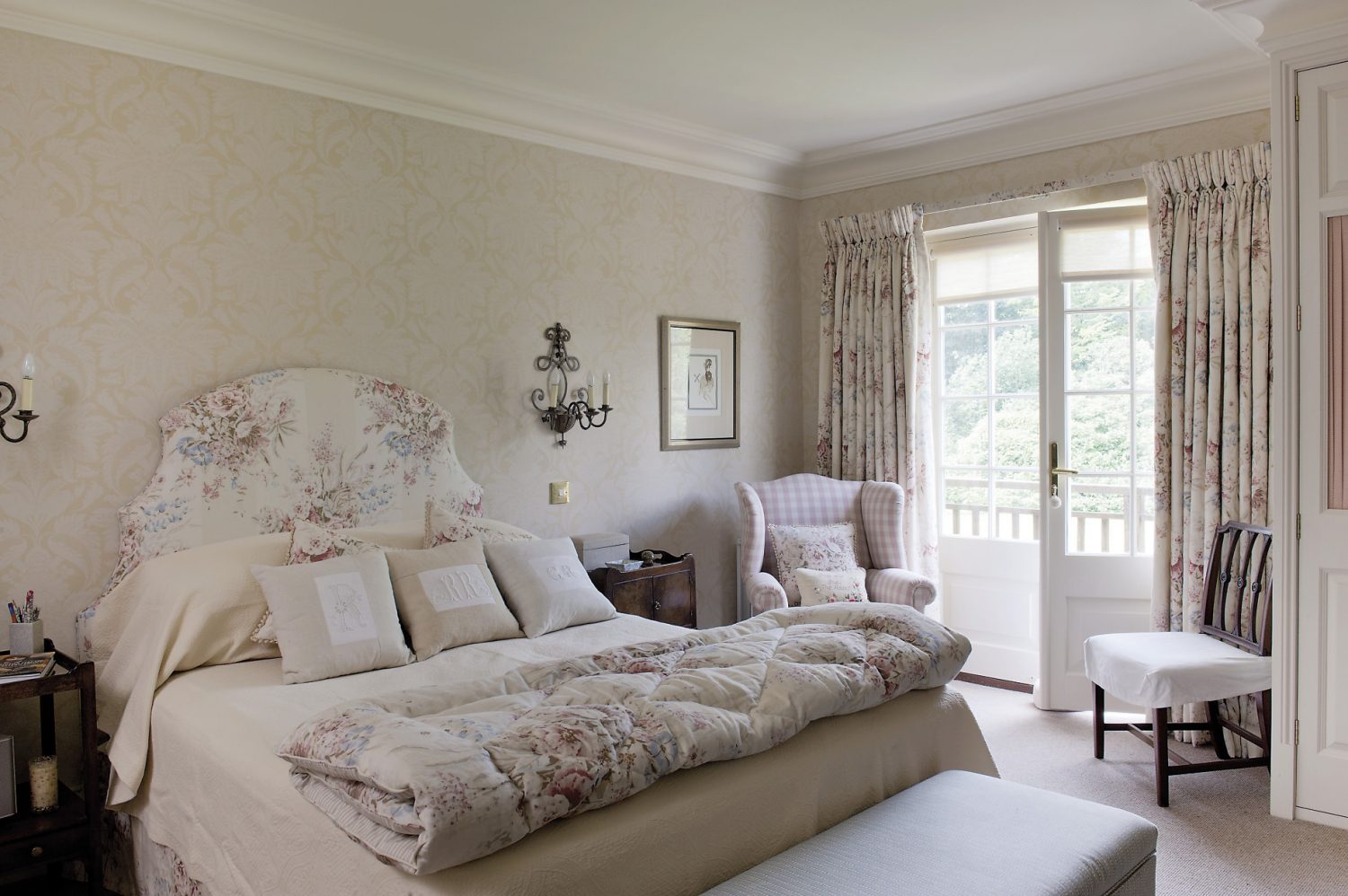 Ro’s bedroom overlooks the garden and has French windows onto a small wooden balcony. The room is light and serene, with a pale wallpaper and a bedhead and curtains made of the same softly coloured chintz