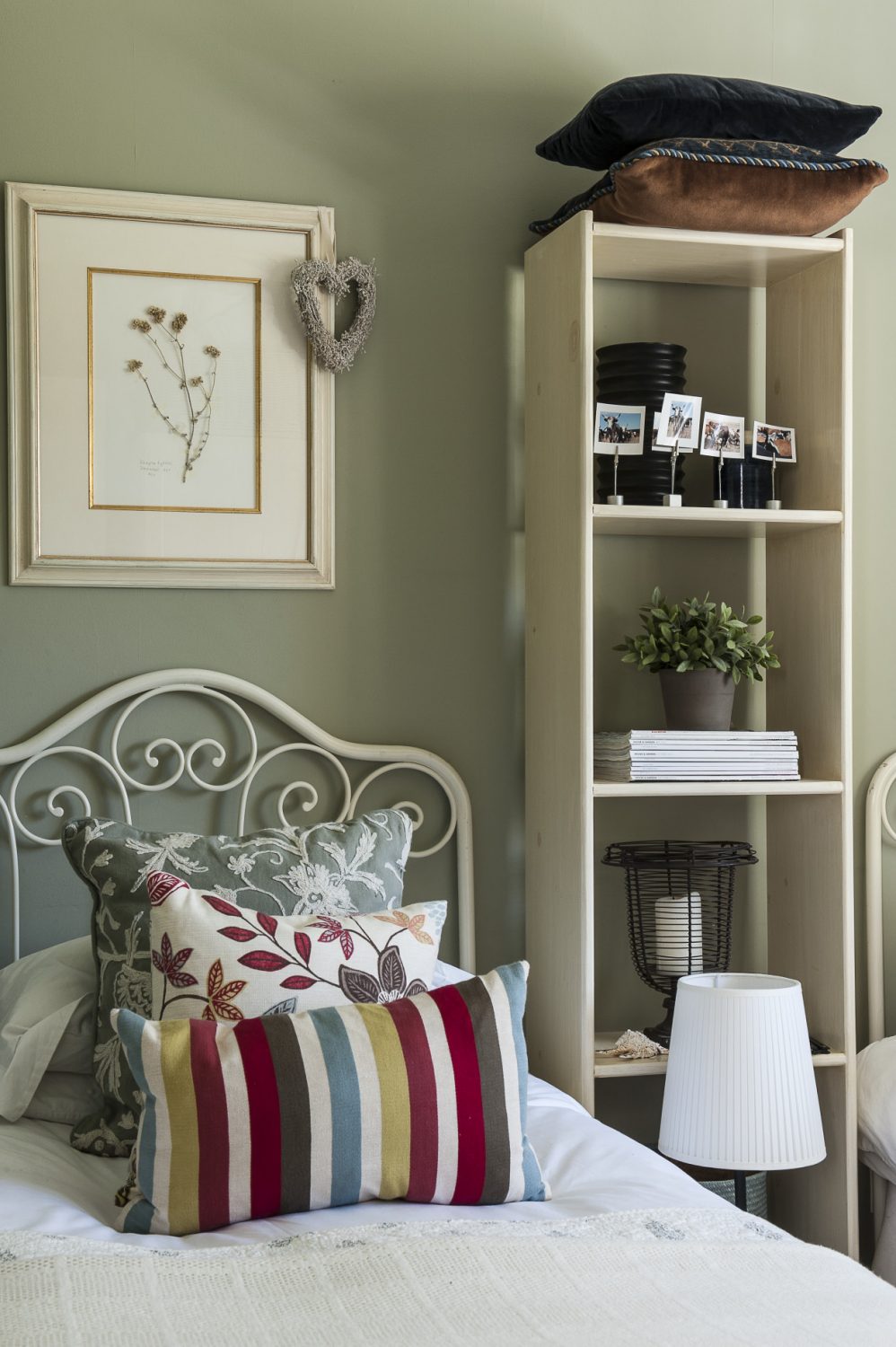 The bright second guest bedroom features delicate wrought-iron headpieces which are actually the matching head and foot of a single bed found in a Tunbridge Wells antique shop