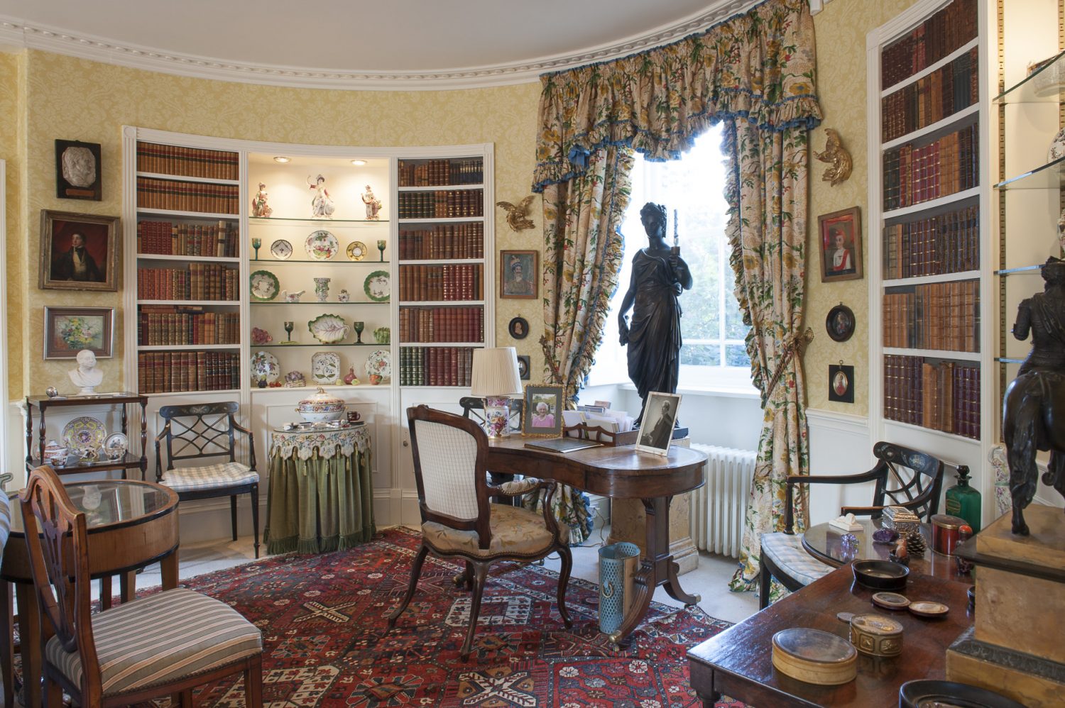 Today, the curved walls of the drawing room, created by a vicar in the nineteenth century, have bookshelves with hidden doors that silently open when pressed in the right spot