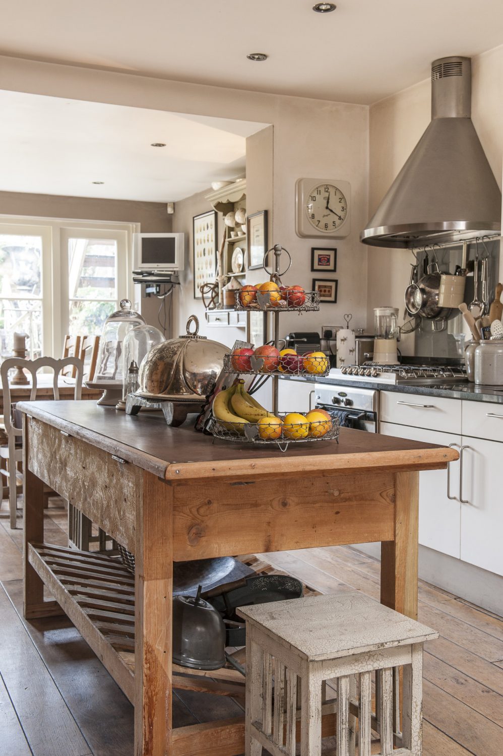 The kitchen section is divided invisibly down the middle – the business side all black granite and steel and the other a far warmer world of soft shades, shadows and antique wood