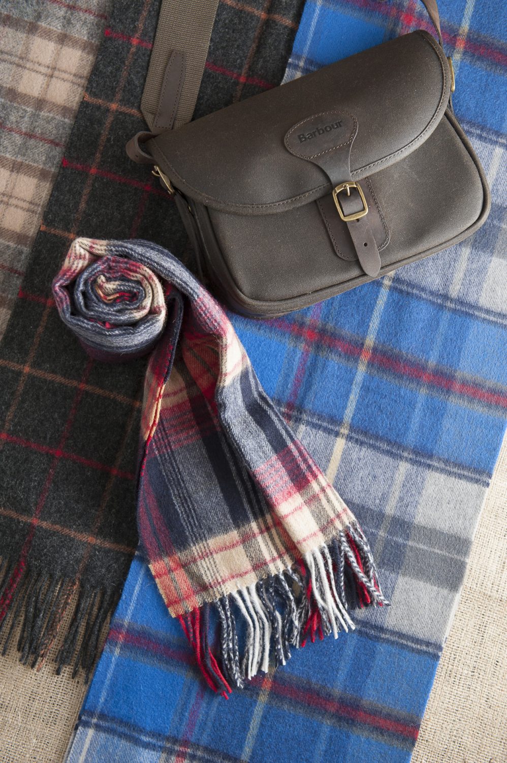 Barbour waxed cartridge bag, £79.95, Barbour lambswool tartan scarves (left, middle and rolled), from £24.95, The Golden Fleece, Rye 01797 224271 www.thegoldenfleece.co.uk; Joules scarf (right), £19.95, Charity Farm Countrystore, Cranbrook 01580 713189 www.charityfarmcountrystore.co.uk