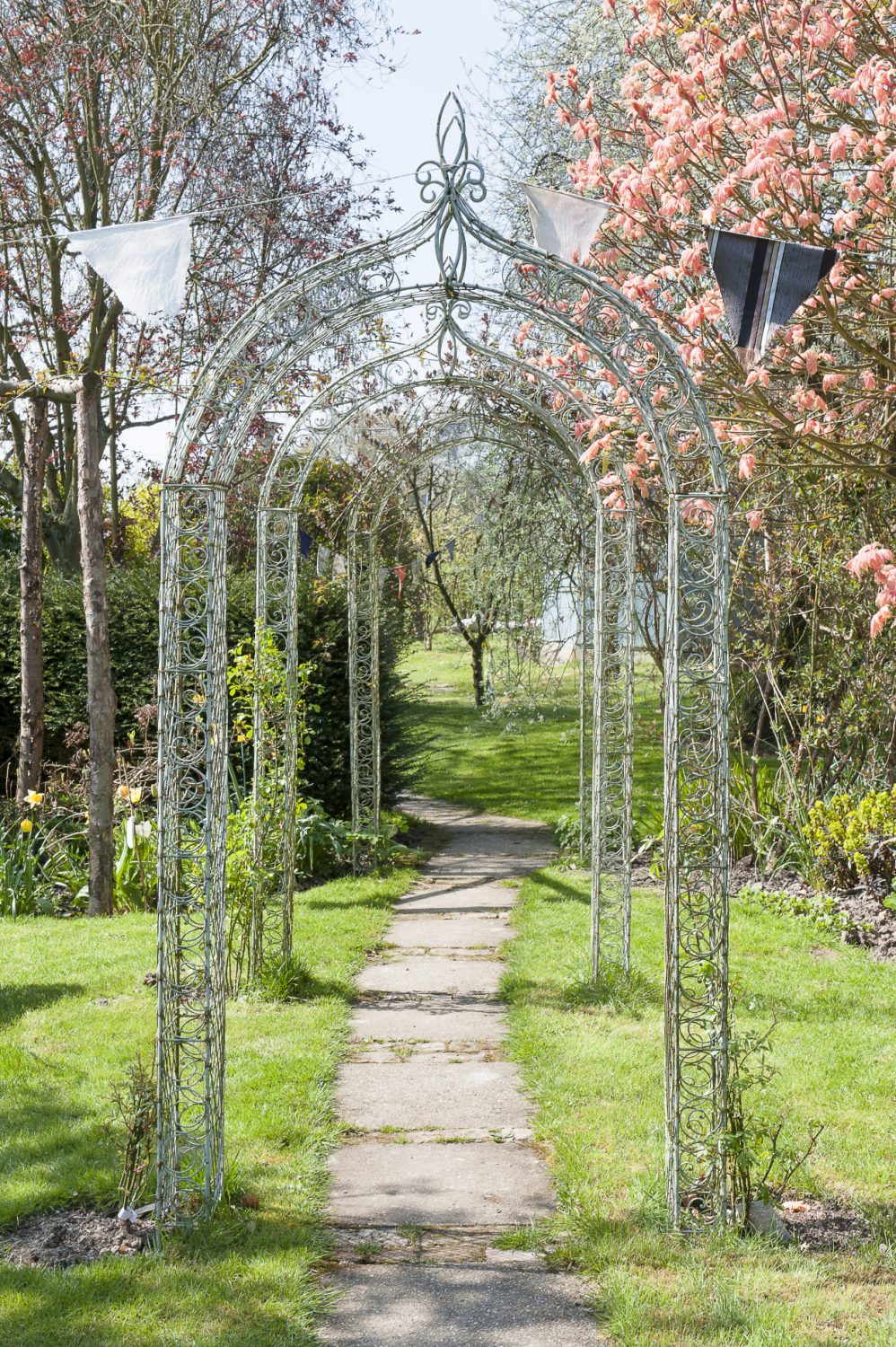 A terraced arbor and a paved path, flanked by daffodils, hydrangeas and tulips, lead down to a summerhouse and chicken coop – home to