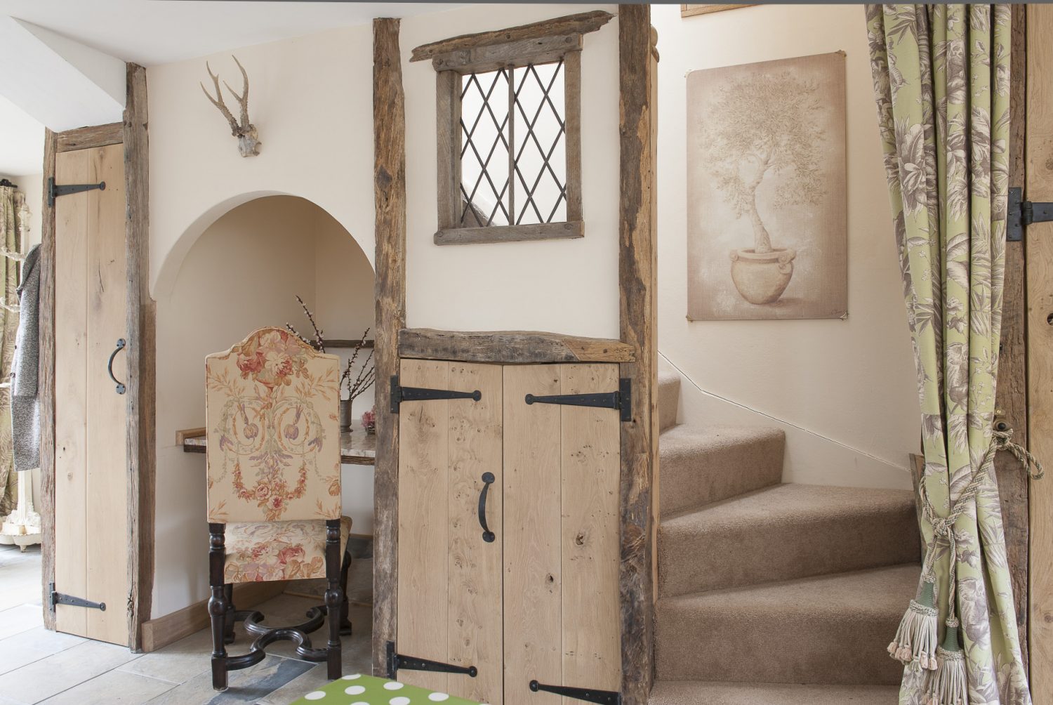 Caroline’s ‘medieval office wall’.A pink marble-topped desk has been fitted into an arched alcove and a leaded light illuminates the ascent upstairs