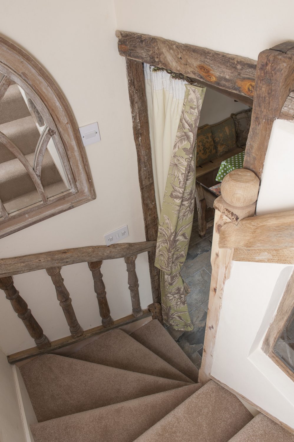 The stairway has been framed in ancient oak whilst oak spindles, left over from the grand reclaimed staircase in Caroline’s own barn home, have been set into the wallsThe stairway has been framed in ancient oak whilst oak spindles, left over from the grand reclaimed staircase in Caroline’s own barn home, have been set into the walls