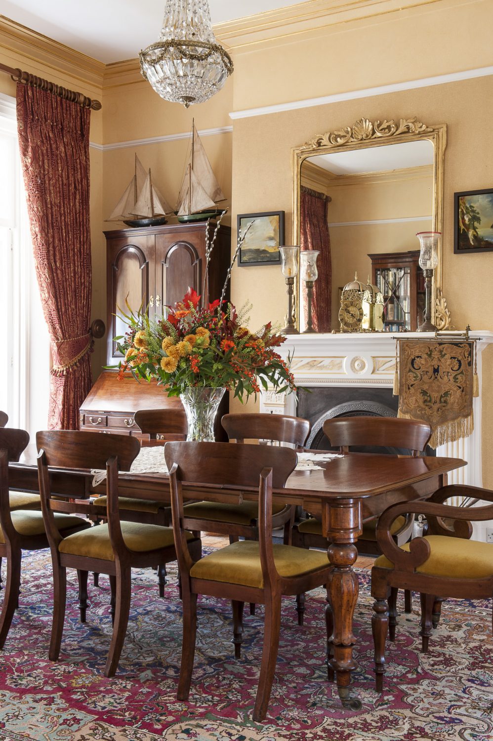 In the formal dining room, above the fireplace, is an elegant 19th century double action brass timepiece. Behind the clock is a Victorian gilt mirror, the twin of which tops a fireplace in Osborne House