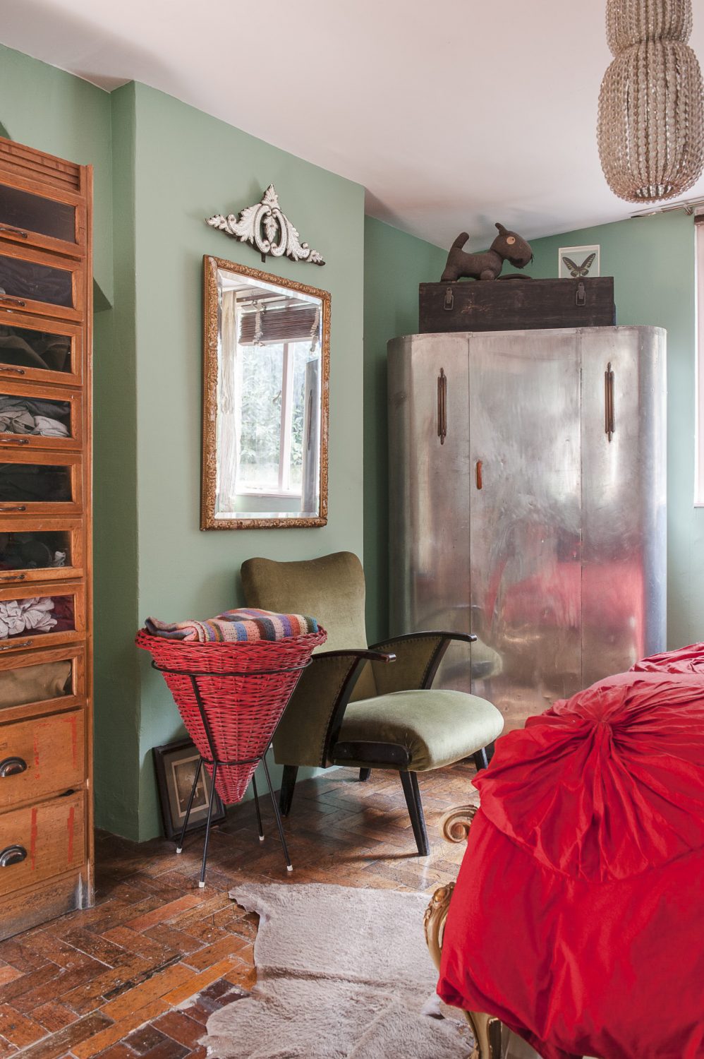 In one corner stands a Deco-style aluminium wardrobe. A toy dog made from an army blanket by Jason’s grandfather during the war sits on top. A 1960s conical French laundry basket stands next to an elegant green 1950s armchair