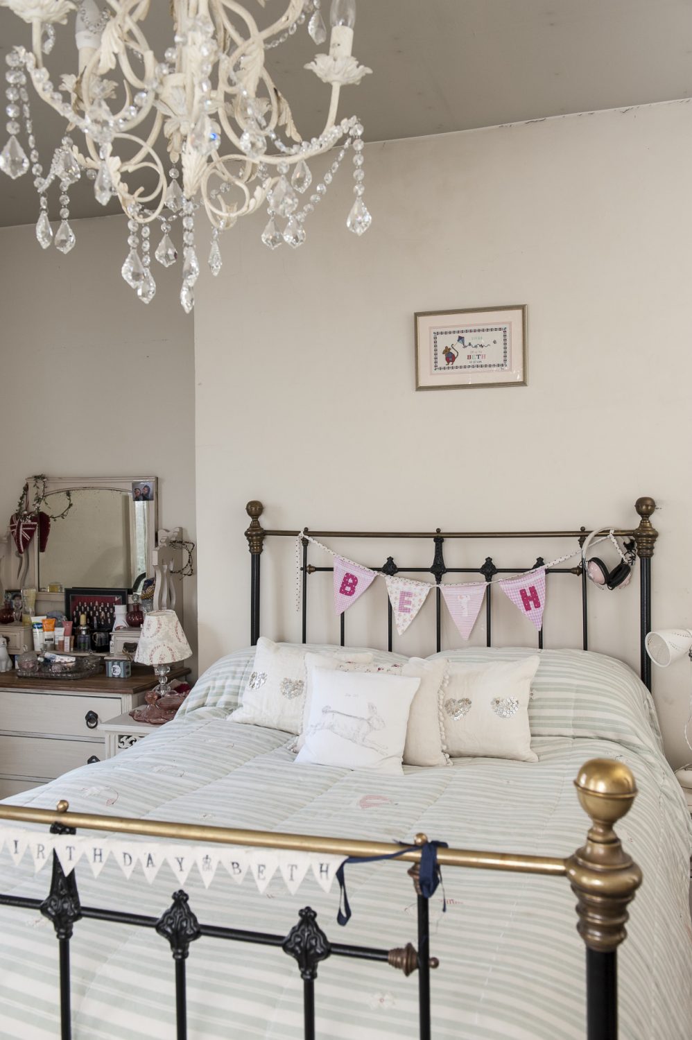 Daughter Beth’s room is graced by a brass and iron bedstead and glass chandelier