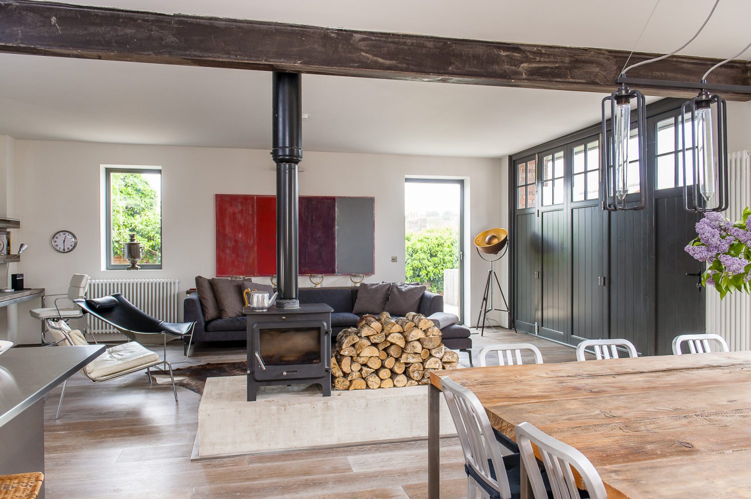 A new set of functional doors have been made in the same style. The double sided wood burning stove and adjacent log pile are housed on a huge concrete plinth, creating a focal point, whether the fire is lit or not