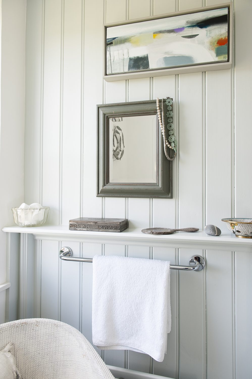 The bathroom features a soft, sea coloured scheme with shells and beach finds arranged on shelves and windowsills. The loo is partitioned away from the bath area, making it separate, but still part of the room
