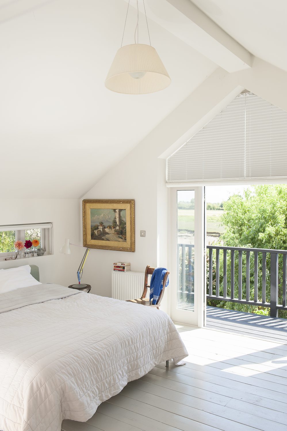 The lofty master bedroom features a balcony which looks out onto the river