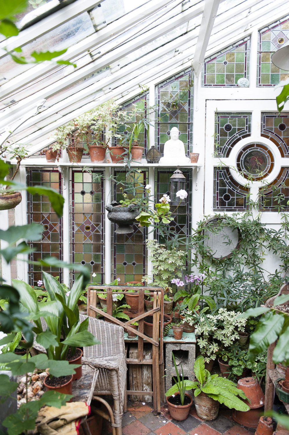 A glasshouse in the garden with stained glass windows