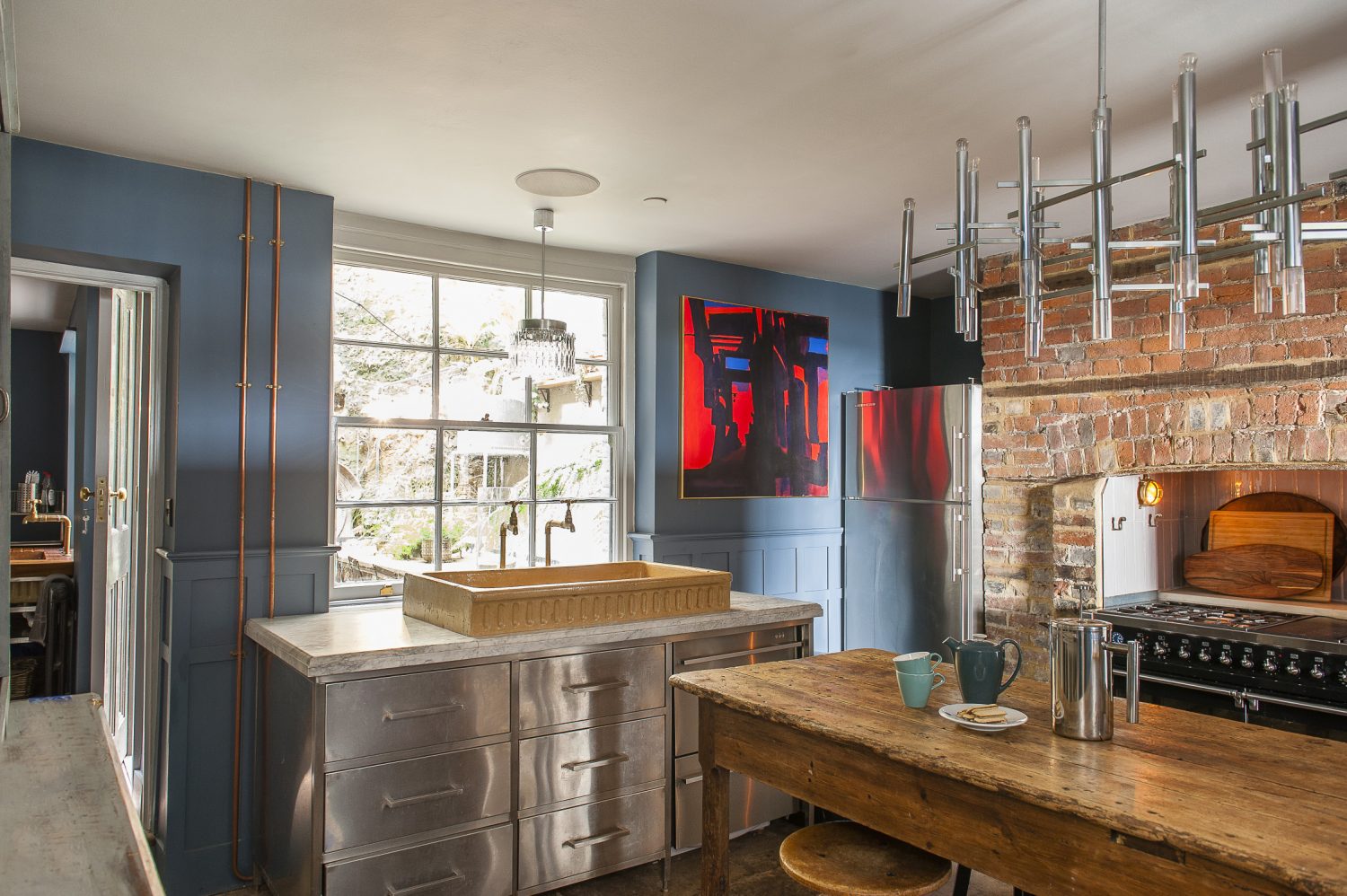 At the heart of the kitchen are a marble-topped stainless steel unit that Shaun had made to house the old stone sink and an 18th century oak refectory table