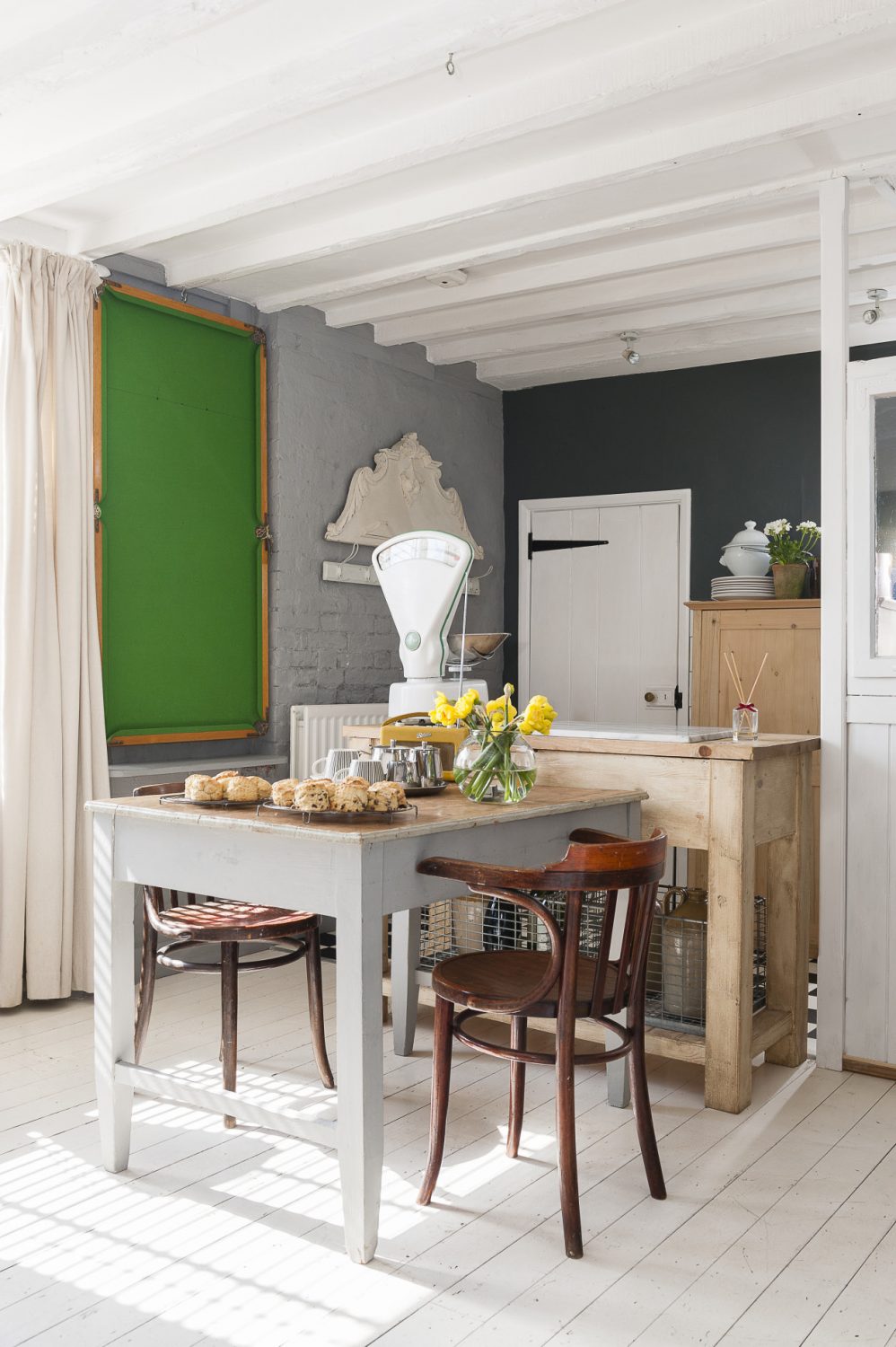 A snooker table hangs decoratively on the wall in the kitchen, bringing a splash of colour to the room, but it’s also just waiting to be taken down for a game – and, by fluke, it fits perfectly on top of the dining table