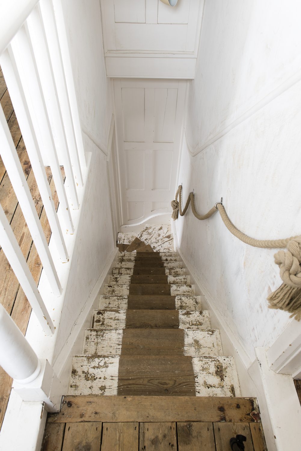 The staircase from the ground floor up to the first floor. The rope handrail is a subtle nod to the maritime connection of the cottage
