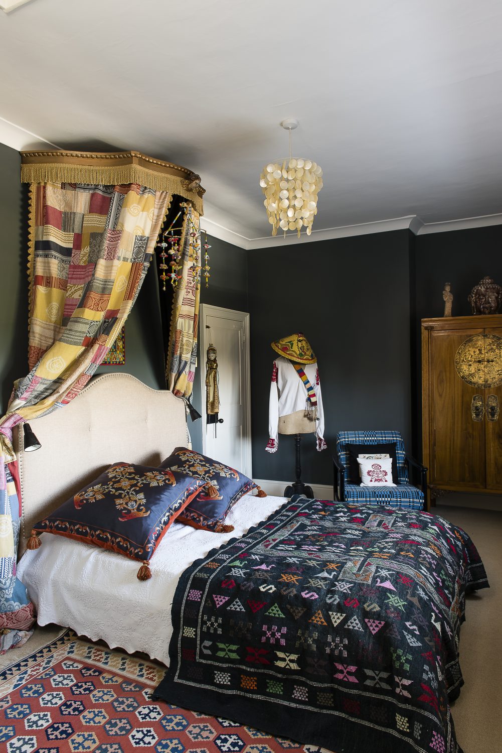 In the 'Traveller's Room' the patchwork bed canopy is made from remnants of Julia's fabrics. The walls are painted in Farrow & Ball Downpipe