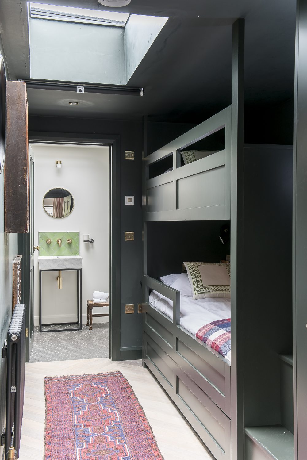 The second bedroom, with two built-in bunk beds, is painted a deep green. Guests often leave messages in an old printer’s tray, into which Amy has put some letter cubes