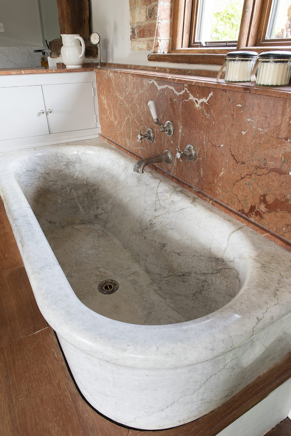 The original master bedroom’s en suite features a deep antique French marble bath