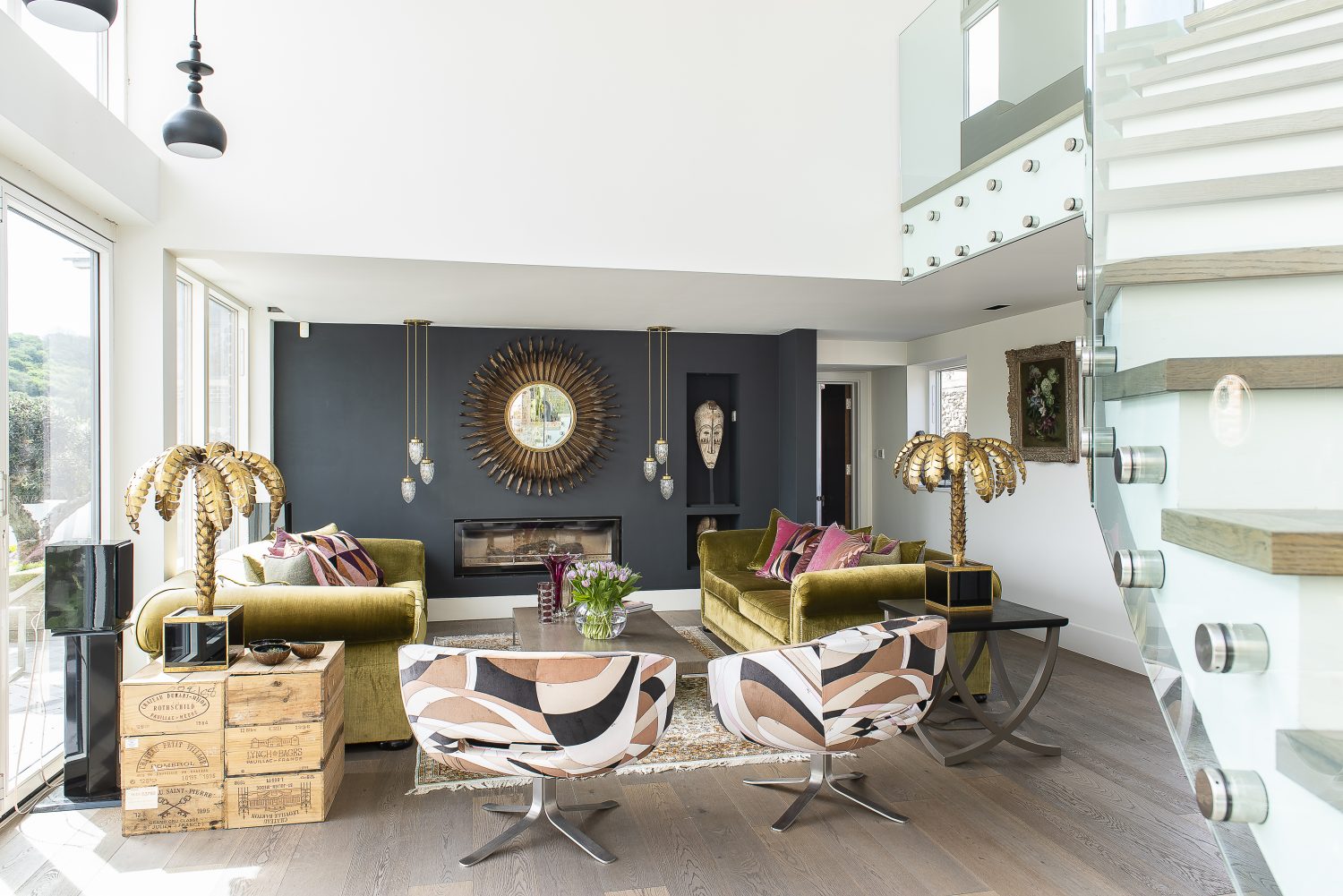 The bright and airy sitting room is home to a pair of 1960s Cappellini swivel chairs covered in original Pucci fabric. The oversized brass pineapple lamps date from the 1950s and the velvet sofas are from the Pfeiffer Design range, which they have made in their own workshop in Eastbourne