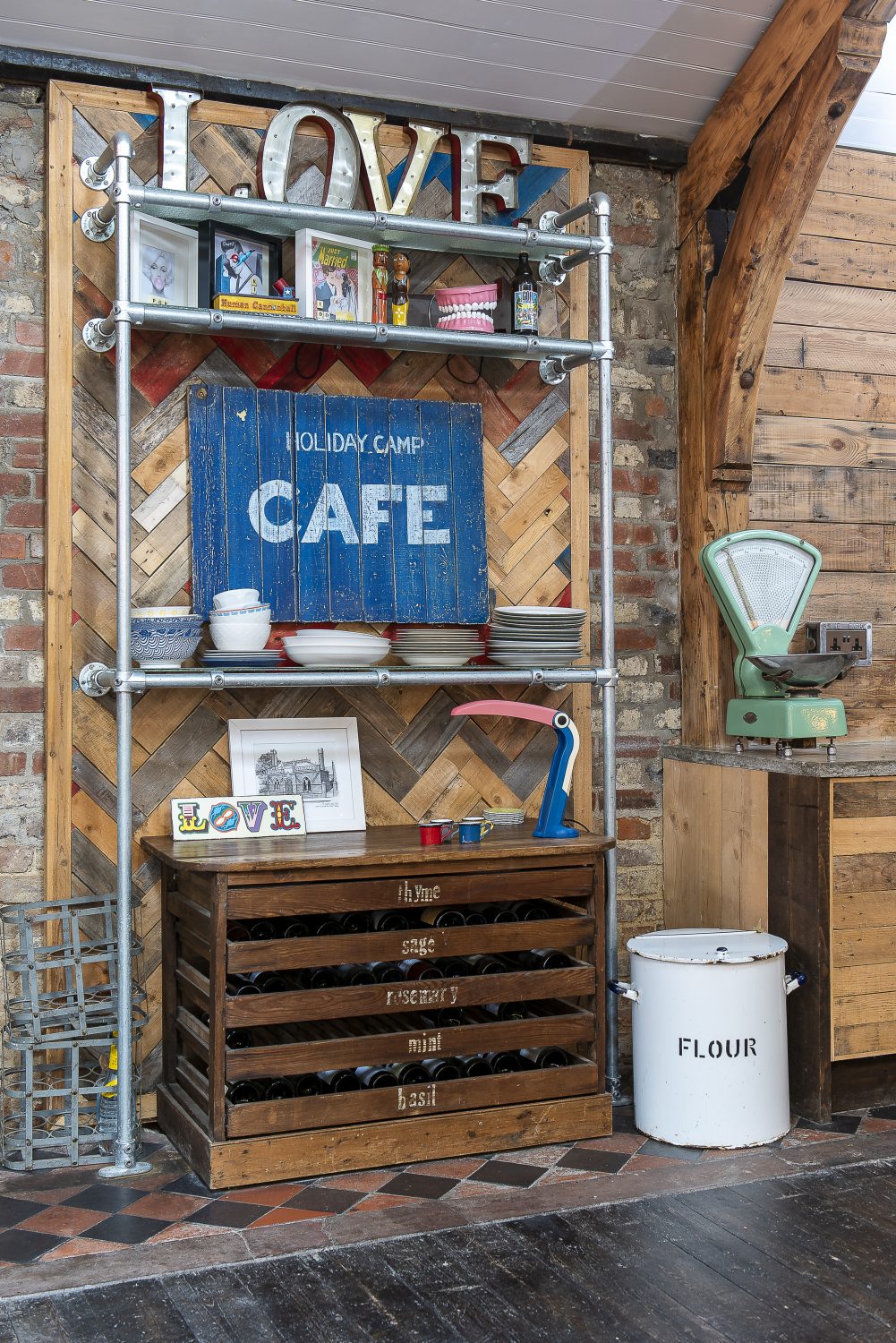 Lengths of reclaimed wood, laid out in a parquet style, make a creative backdrop to shelving in the kitchen