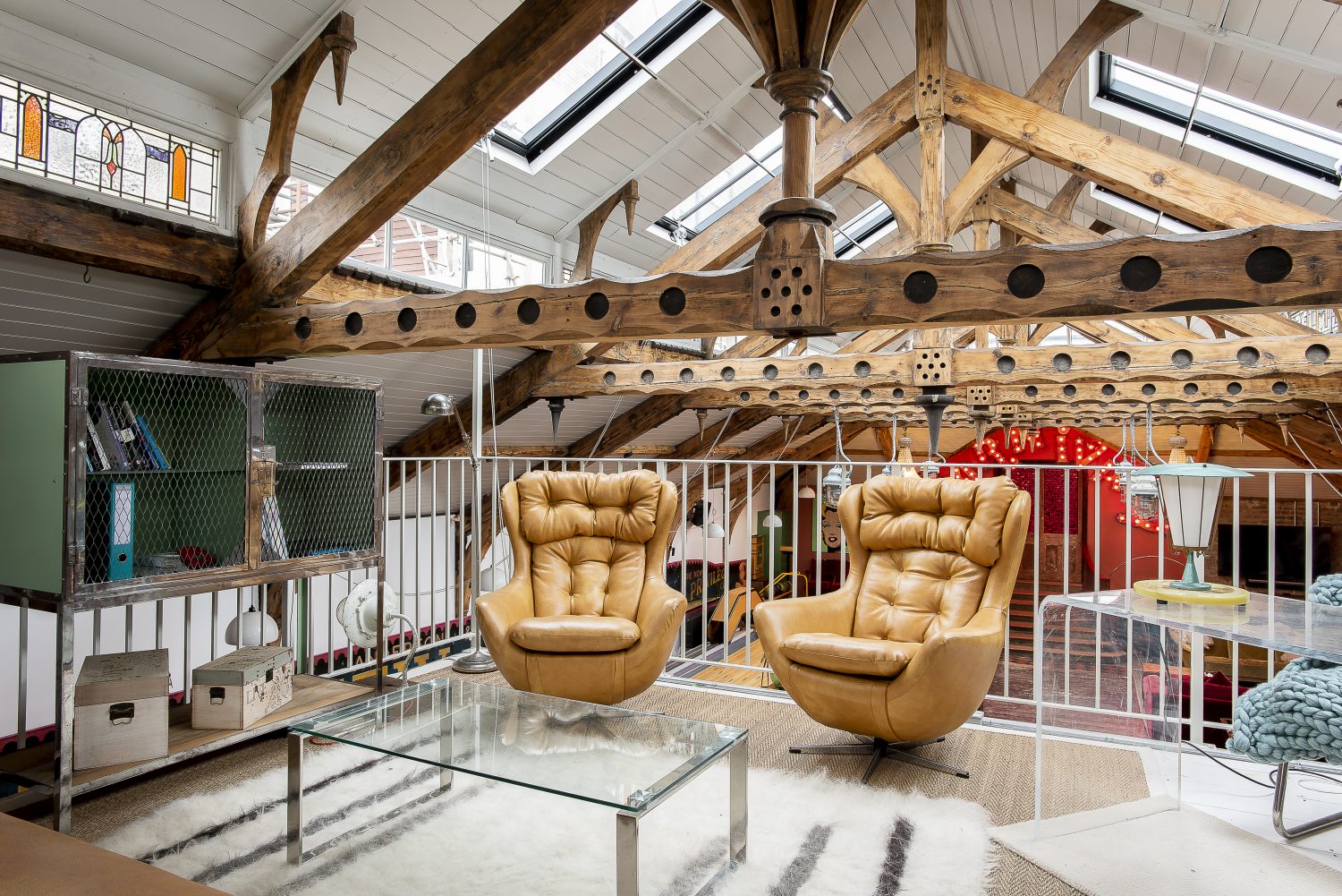 A mezzanine provides an office space and seating area above the kitchen