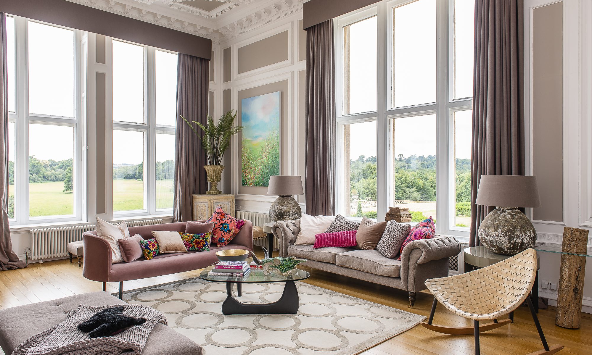 In the sitting room, Jaime has kept the colour palette to neutral greys and browns with white detailing. The double aspect windows take centre stage, with beautiful views out over the Bayham gardens