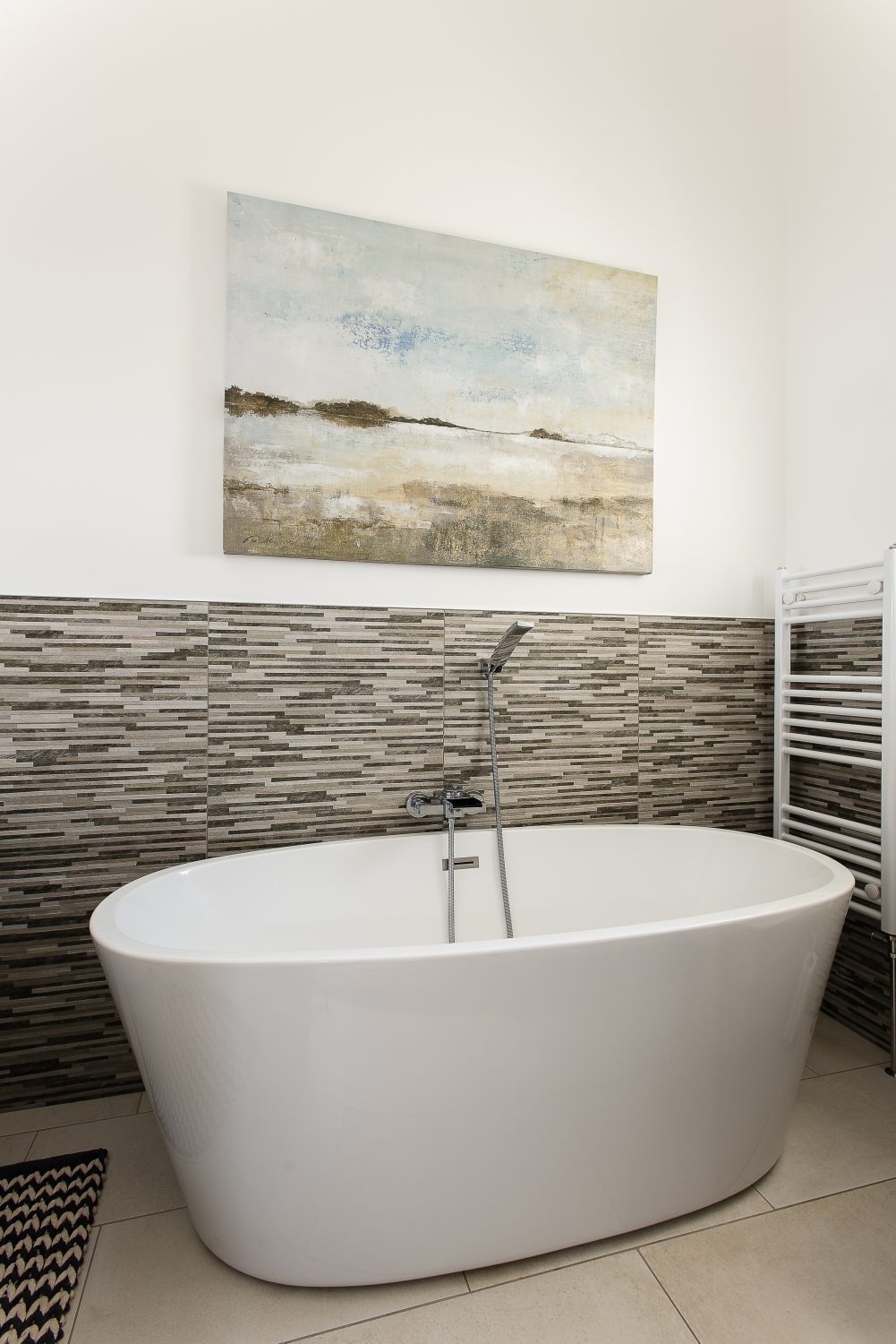 Two bathrooms, one accessible from two doors, have been stylishly fitted with a contemporary bath and shower. One of the bedrooms retains its original wooden tongue and groove cladding. “We started to sand it off,” says Kelly, “but liked the effect of leaving some of the green on the wood underneath.”