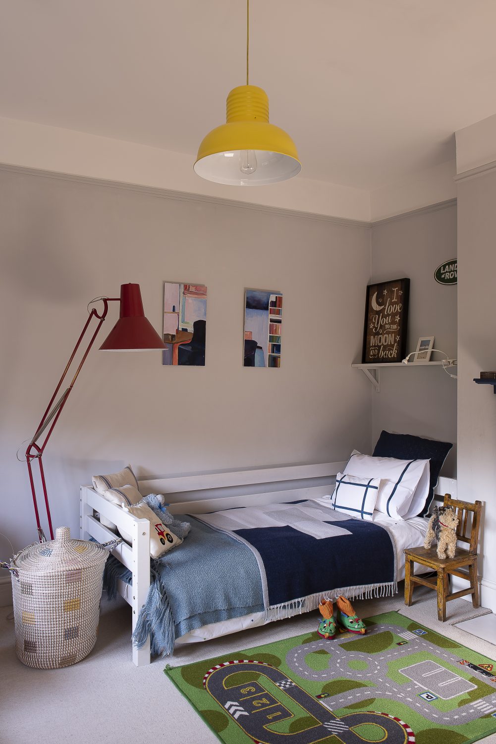 In the couple’s son’s room, Farrow & Ball’s Stiffkey blue used for the fireplace works well with the red Anglepoise and yellow lampshade