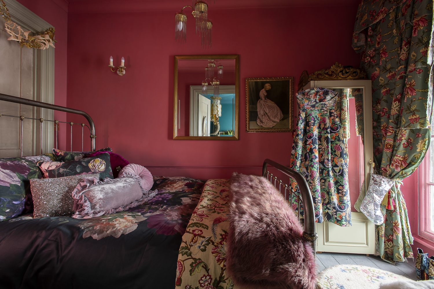 The wonderfully romantic bedroom is like a film set from the 1950s. The room is taken up almost entirely by a steel bed, made up with dramatic floral bed linen, from John Lewis, dressed with a floral counterpane and a purple fake fur throw