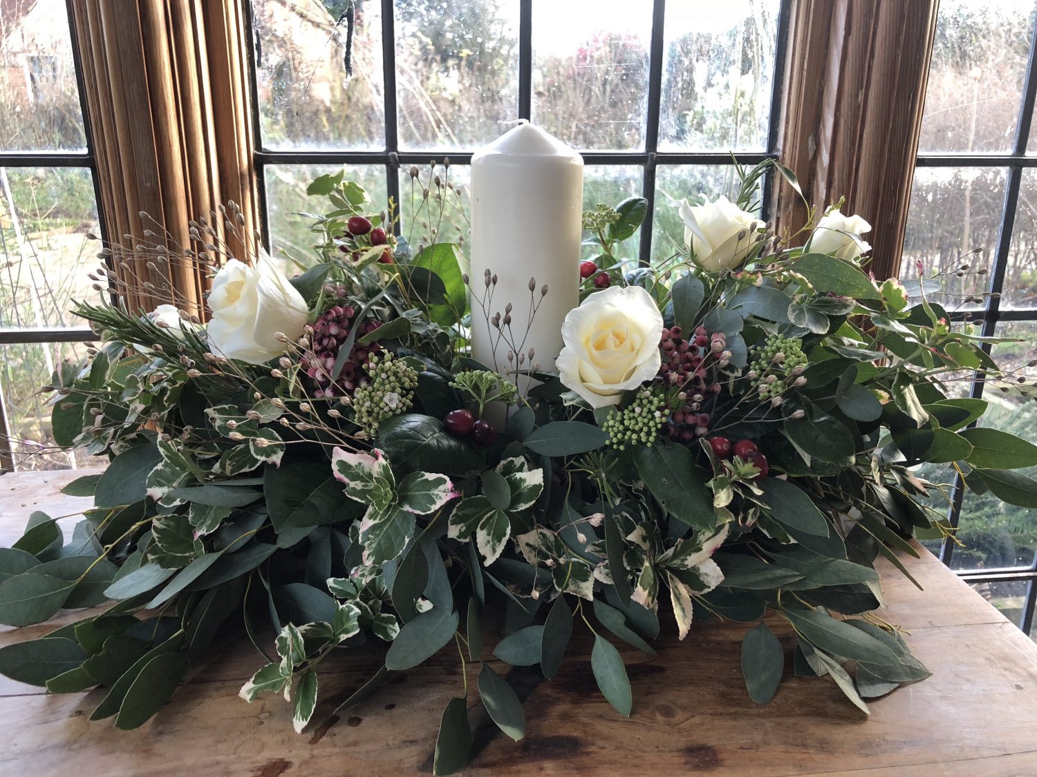 Table decoration using shop bought roses and foliage from the garden