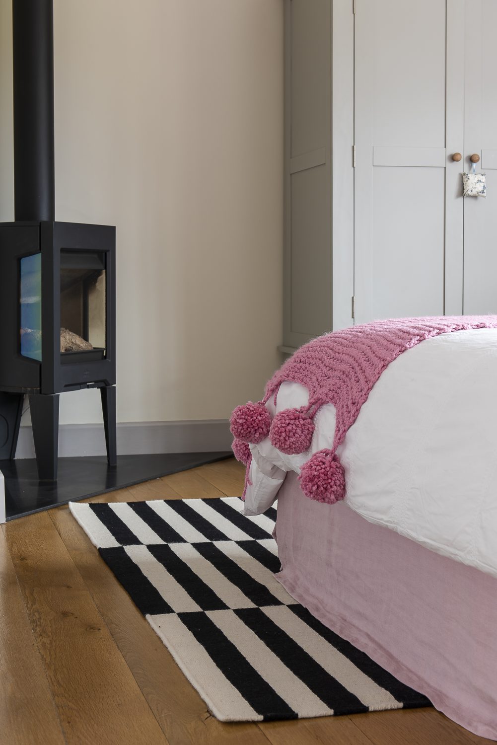 The ‘Rose Room’ follows a pink theme with lights by Pooky, an Ikea rug and a cosy woodburner in one corner