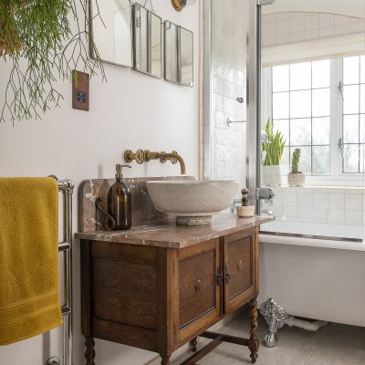 Justine has turned the small bathroom into a hotel-standard space, with a vintage free-standing vanity unit and brushed brass taps that perfectly reflect the aesthetic in the rest of the house. More houseplants lend a vibrant feel