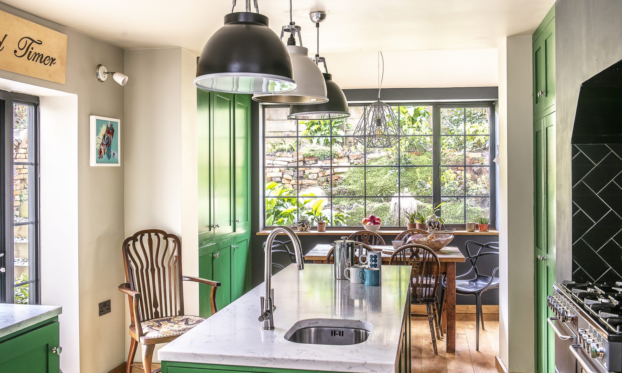 The cabinet work and cupboards in the kitchen have all been painted in a bright grass green, Sadie’s favourite colour, with black accent walls around the range cooker and the picture window