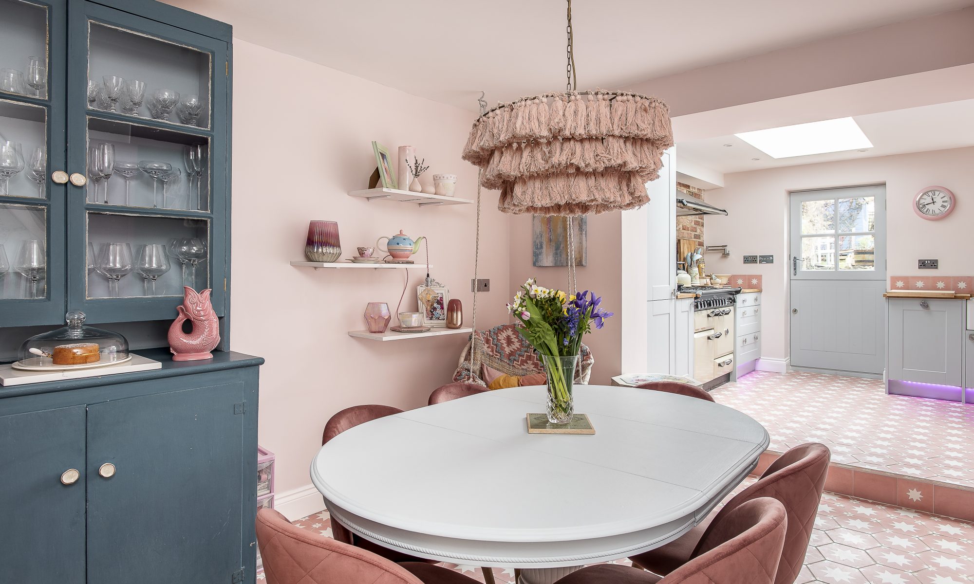 A huge pink lampshade by Anthropologie hovers over the dining table. The tiles on the walls in the kitchen, from Bert & May, miraculously match the floor tiles