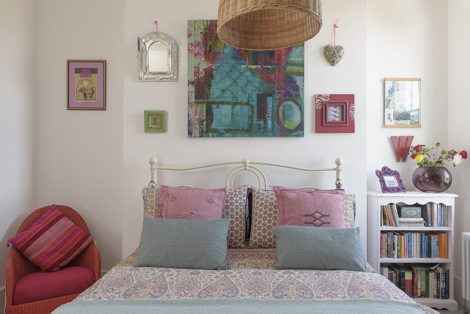 A colourful guest bedroom is filled with artworks collected on the couple’s travels 