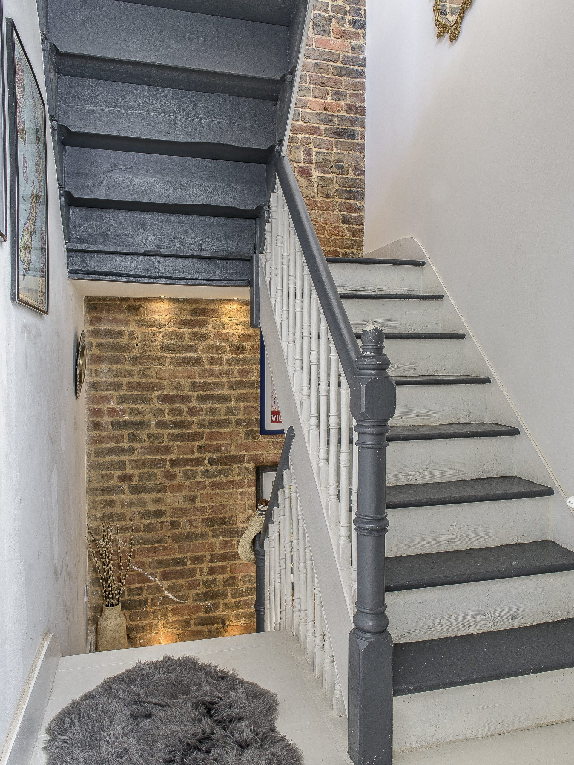 The house has a distinctly artistic loft atmosphere with exposed brickwork and a palette of whites and greys. 