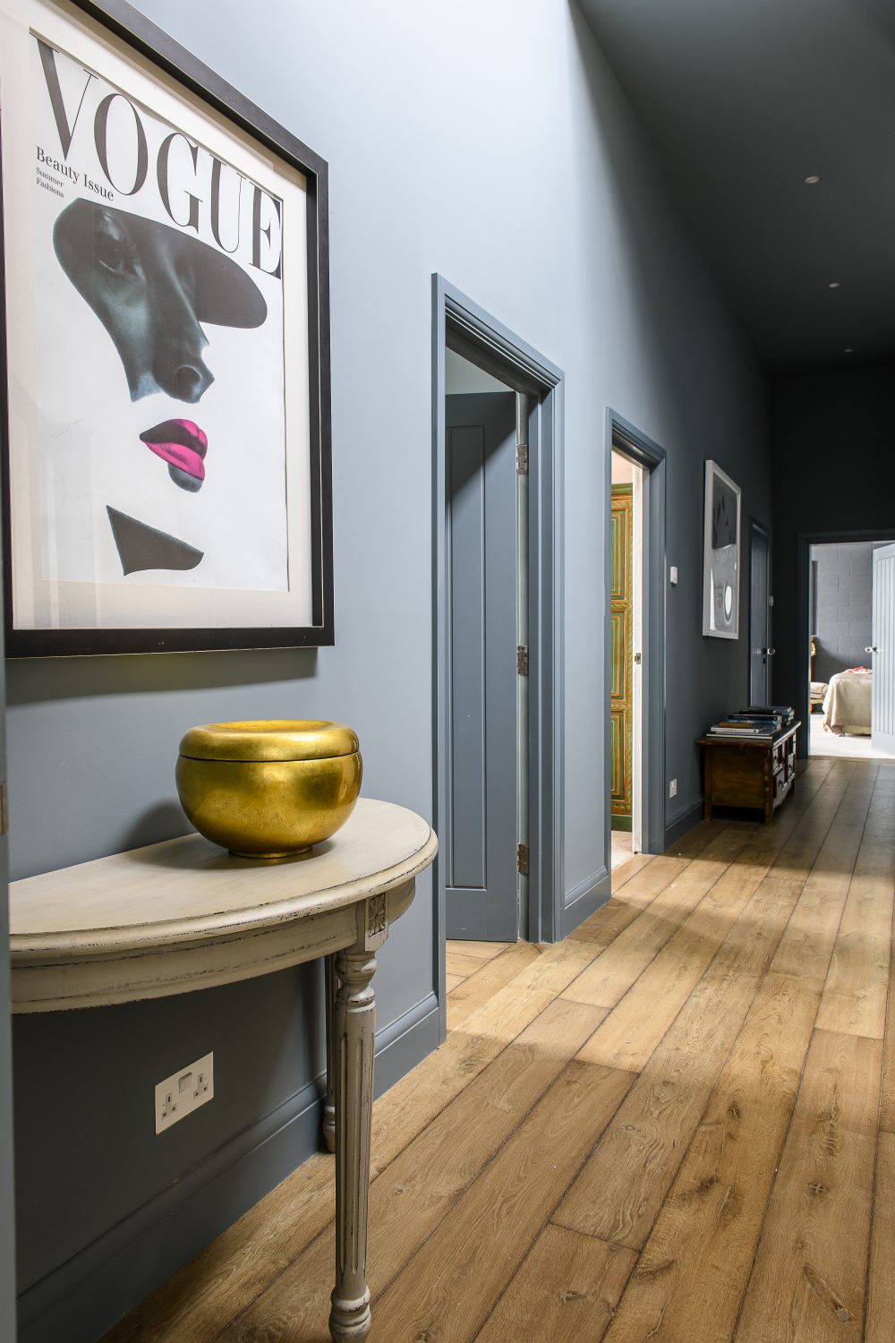 The bedroom hallway is painted in De Nimes by Farrow & Ball. A limited edition Vogue poster hangs above a Chinese bowl