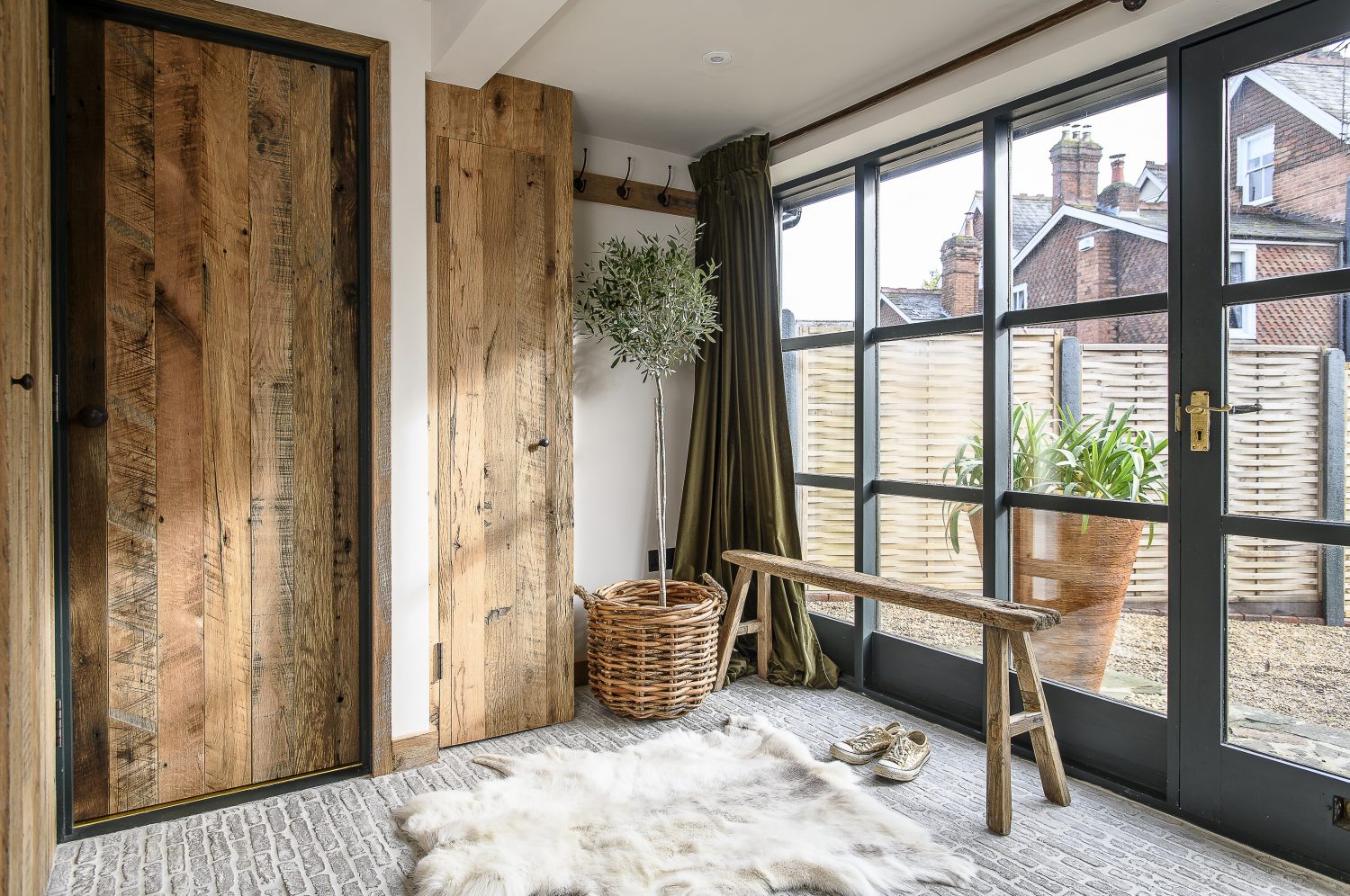 “All the doors are made from reclaimed Mississippi oak floorboards.” This gives them their rich warm colour and contrasts beautifully with the central section of the door frames, painted in a smokey blue