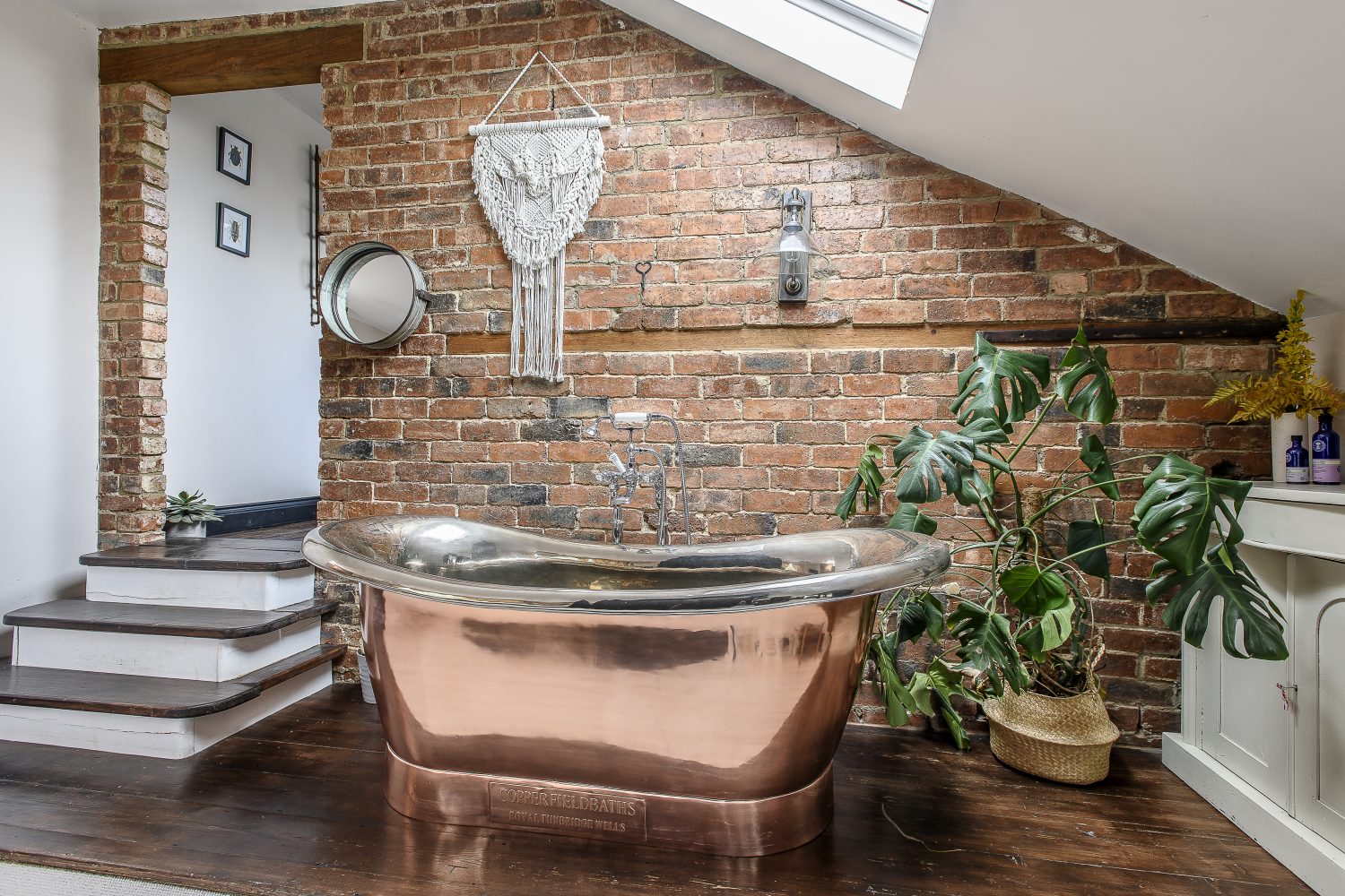 In one corner of the bedroom a freestanding Copperfield bath bathes in light from the skylight above Left: When a new opening was created to allow access to the master en suite, bricks were stripped of plaster and left untrimmed